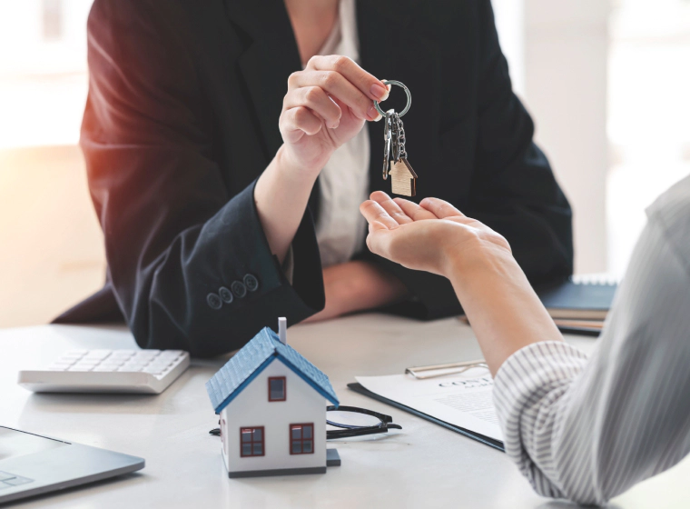 woman giving key to the new residential owner woman giving key to the new residential owner